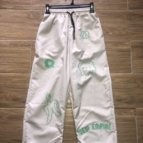 SP419 PANTALON BEIGE TIPO CALENTADOR AL CUERPO Y A LA VEZ SUELTO, CON ADORNOS VERDES, UNO EN FORMA DE FLOR Y FANTASMITA , CON ELÁSTICO Y CORDÓN NEGRO